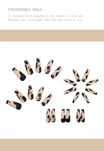 Détail de faux ongles ballerine longs avec motif vache mat beige et noir press-on nails