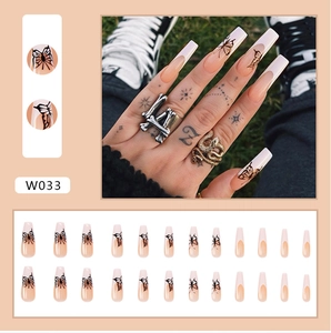 Detail of long ballerina press on nails with nude French base and black butterfly art
