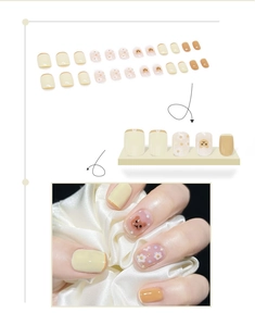 Detail of short square-oval press-on nails with cartoon bear and daisy floral patterns