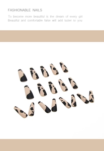 Détail de faux ongles Coffin mats avec motif vache en beige et noir élégant