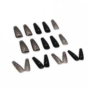 Glossy black and translucent grey coffin press-on nails with glitter accents on white background