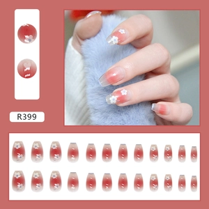 Detail of pink gradient press-on nails with white flower patterns and 24-piece full set