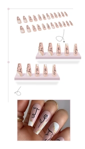 Detail of long coffin press-on nails with abstract hand-painted line art and gold foil