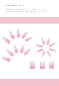 Close-up of long coffin-shaped pink ombre press-on nails with delicate rhinestone accents