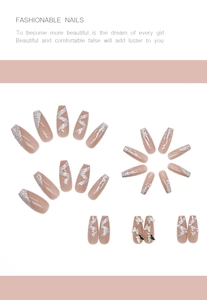 Detail of nude pink press-on nails with silver glitter, metal butterflies and pearls