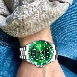 Close-up of luxury green dial quartz watch with stainless steel strap on a male wrist