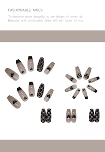 Detail view of long coffin press-on nails with black heart and checkerboard patterns