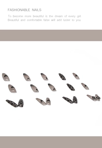 Detail of long coffin false nails featuring black heart patterns and 3D bow accents