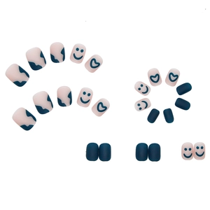 Matte blue and pink press-on nails with cow print, heart and smiley face designs