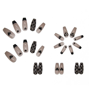 Long coffin press-on nails featuring black heart and checkerboard patterns in glossy finish