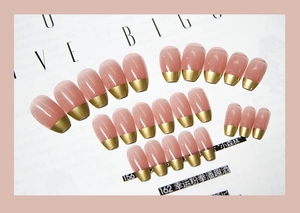 Détail de 24 faux ongles français roses avec pointes dorées et finition brillante