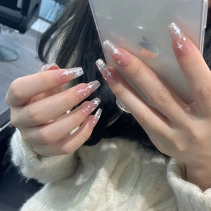 Long coffin press-on nails with nude glitter tips and silver star designs