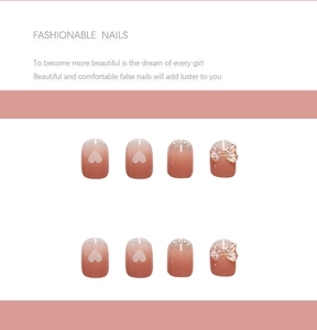 Detail of pink gradient press-on nails with pearl accents and 3D transparent bows