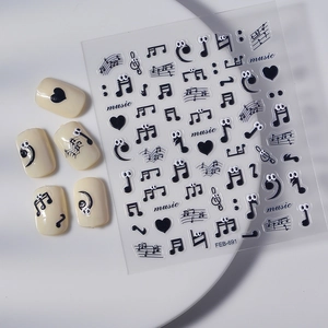 Black music note nail stickers with cartoon eyes and sheet music design on white tray
