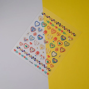 Detail of 5D embossed heart nail stickers with gold foil outlines and floral patterns