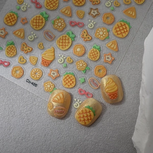 Macro shot of 3D pineapple nail stickers with relief texture and vibrant fruit patterns