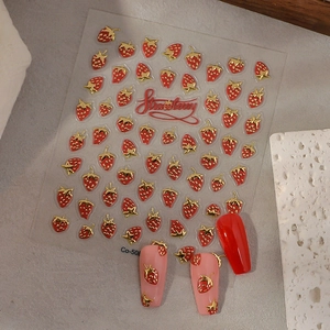 Detail of DIY strawberry nail art stickers with red and gold 3D embossed designs