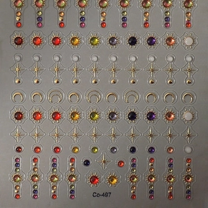 Star and moon themed celestial nail stickers with gold embossing and colorful gemstone patterns