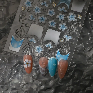 Detail von CO-519 blauen Blumen-Nagelstickern mit Goldakzenten und 3D-Muscheltexturen