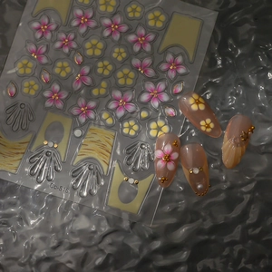 Detail showing 3D pink flower nail stickers with gold accents and applied effect