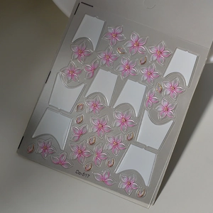 Detail view of 3D pink cherry blossom nail stickers with gold edges and French tips