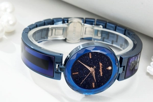 Macro detail of starry blue watch dial with rose gold markers and stainless steel strap