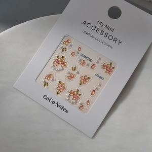 Detail of 3D embossed floral nail stickers with pearls and pink rhinestones on display card