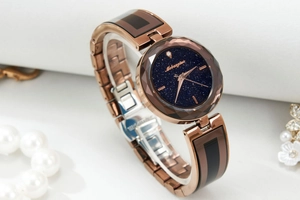 Detailed side view of luxury starry sky watch with faceted glass and rose gold strap