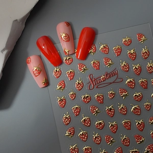 3D strawberry nail art stickers with gold embossed details on glossy red finish