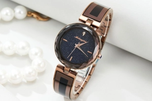 Detailed macro view of starry blue dial and faceted glass of this rose gold women watch