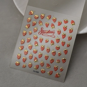 Macro shot of 3D embossed red strawberry nail stickers with gold leaf details
