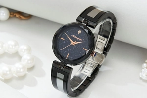 Detail of star dial watch with rose gold hands and faceted crystal bezel on white