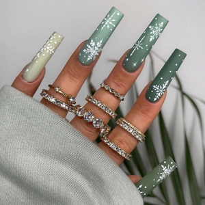 Detailed view of Christmas green gradient press-on nails with white snowflakes and gold rings