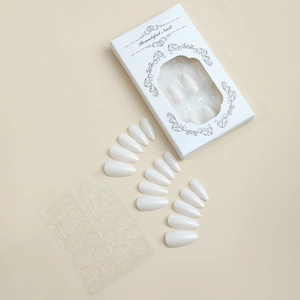 Detail view of almond white press-on nail set with adhesive tabs and minimalist box