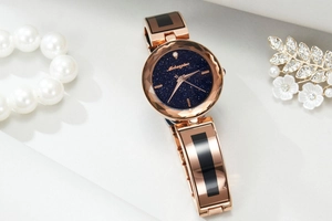 Detailed close-up of a rose gold women watch with starry blue dial and diamond-cut bezel