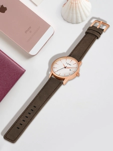 Detail view of TOMI minimalist watch with rose gold case, date window and brown leather strap