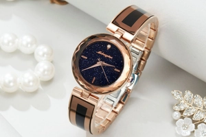 Detail of rose gold quartz watch with starry blue dial and black enamel metal strap