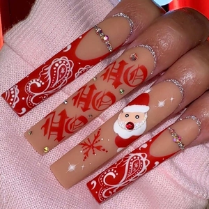Macro view of Christmas press-on nails with Santa art and paisley pattern details
