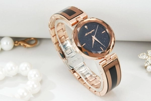 Detail of rose gold starry sky watch featuring multifaceted glass and blue galaxy dial