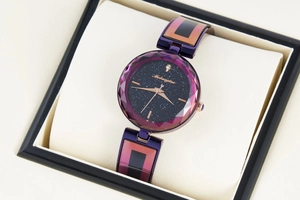 Detailed close-up of faceted purple glass and star sky dial on a luxury women watch