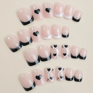 Valentine style press on nails with nude pink base and black heart patterns
