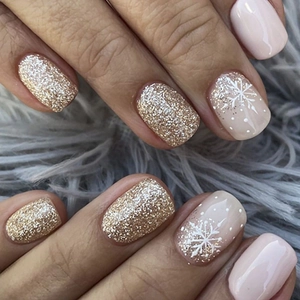 Detail of Christmas press on nails with white snowflakes and gold glitter accents