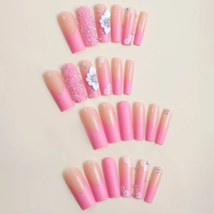 Pink press-on nails with 3D white flowers, French gradient, and sparkling rhinestones