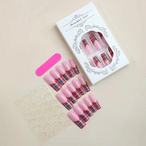 Detail view of XXL long pink coffin nails with red and green plaid patterns and gold studs