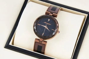Close-up of starry sky dial and faceted glass crystal on rose gold quartz watch