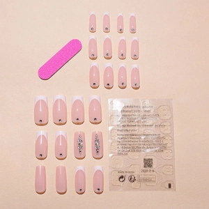 Pink French fake nails set with white tips and sparkling rhinestones plus tools