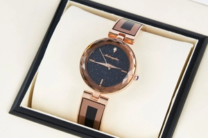 Detail of starry sky dial and faceted bezel on women's rose gold quartz watch