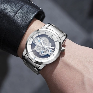 Detailed view of silver stainless steel skeleton watch showing internal mechanical gears