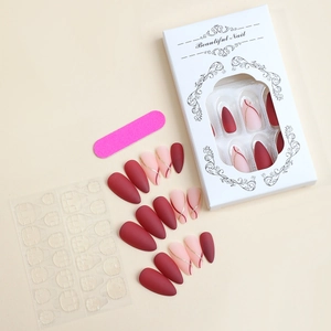 Detailed set of burgundy and pink press-on nails with golden line art and tool kit