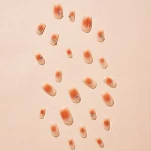 Short square press-on nails with blush gradient design and sparkling rhinestone accents